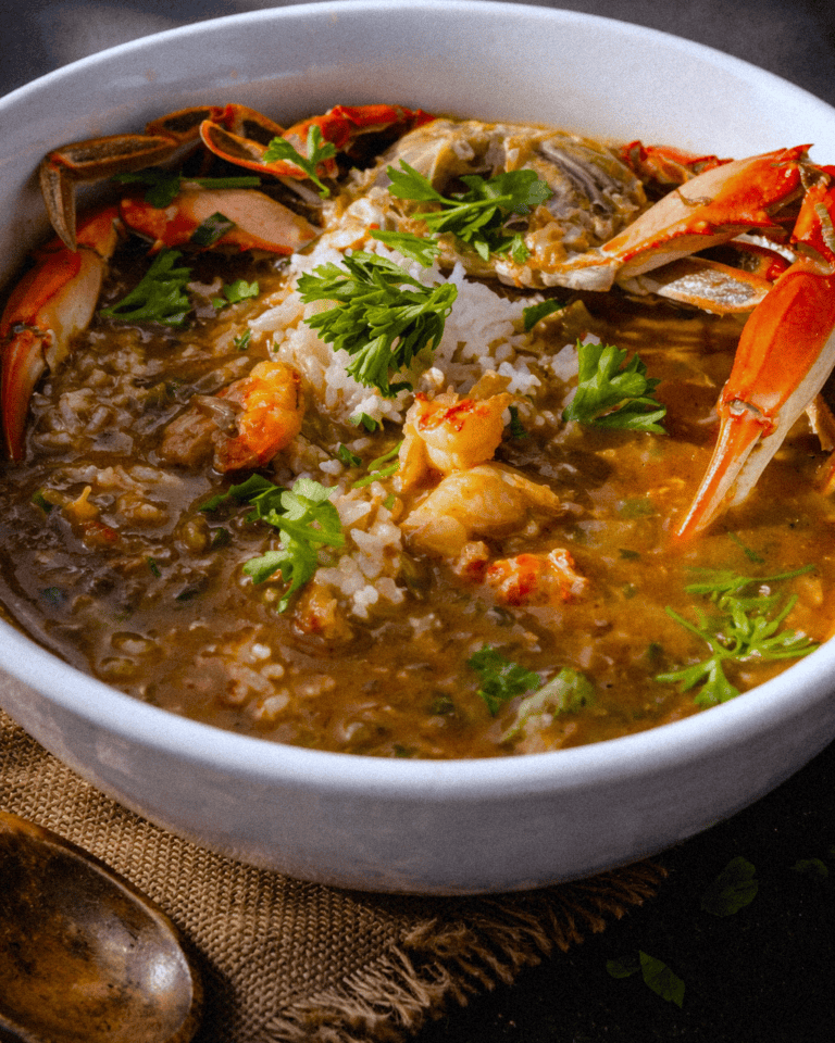 A flavorful seafood gumbo with shrimp, crab, and rice garnished with fresh herbs.