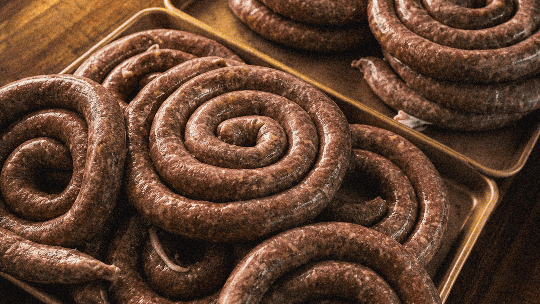 Traditional Cajun and Louisiana-style smoked sausage coiled on a wooden tray.