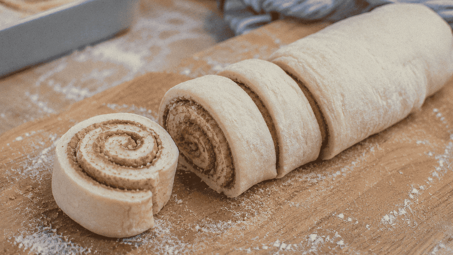 Cinnamon roll dough being rolled out on a floured surface in Louisiana kitchen.